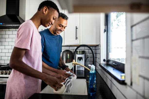 Father and son washing dishes at home