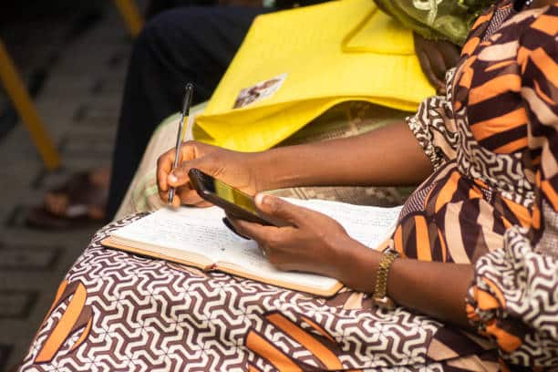 woman with a pan and book doing market research.