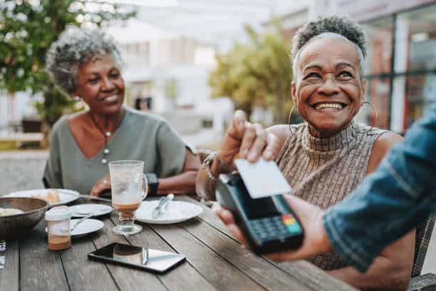 Senior woman making credit card payment for errand service